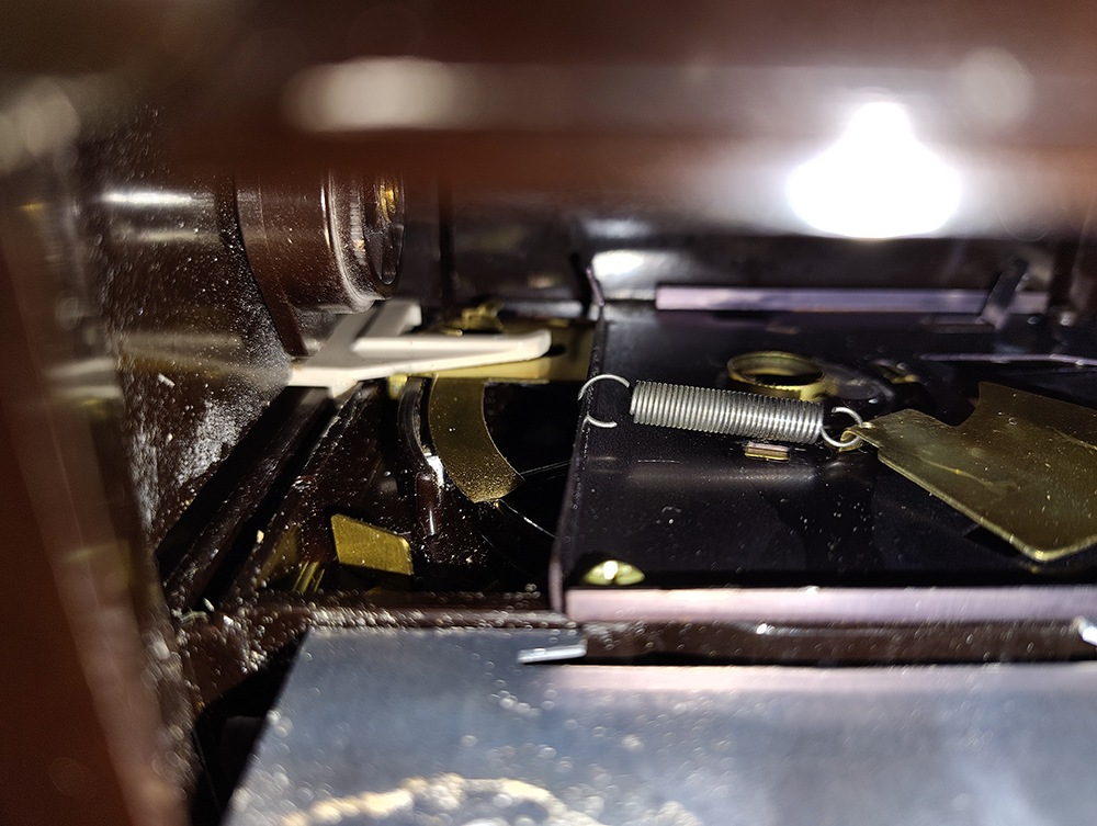 The broken lever and how it should fit on the mechanism.